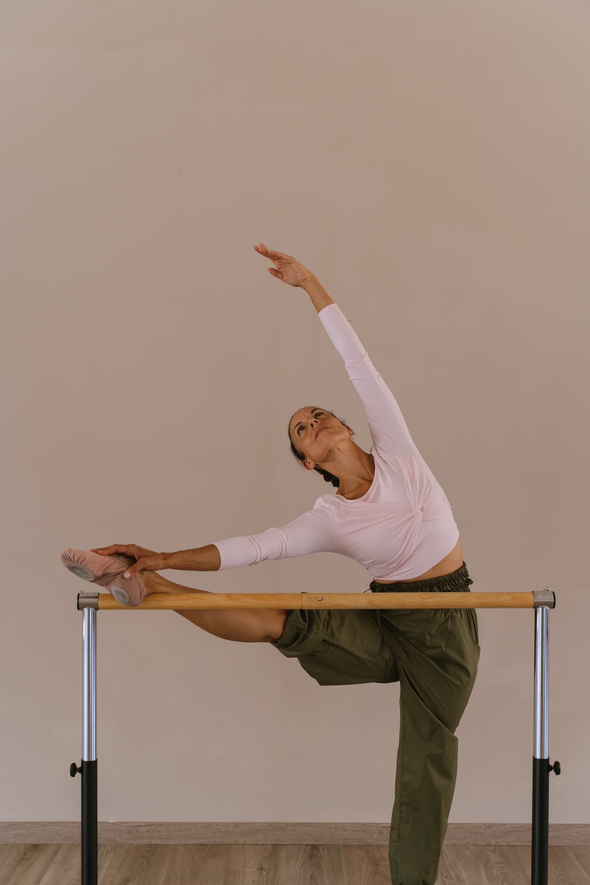 Alumna estirando en la barra en una clase de BVRRE Ballet