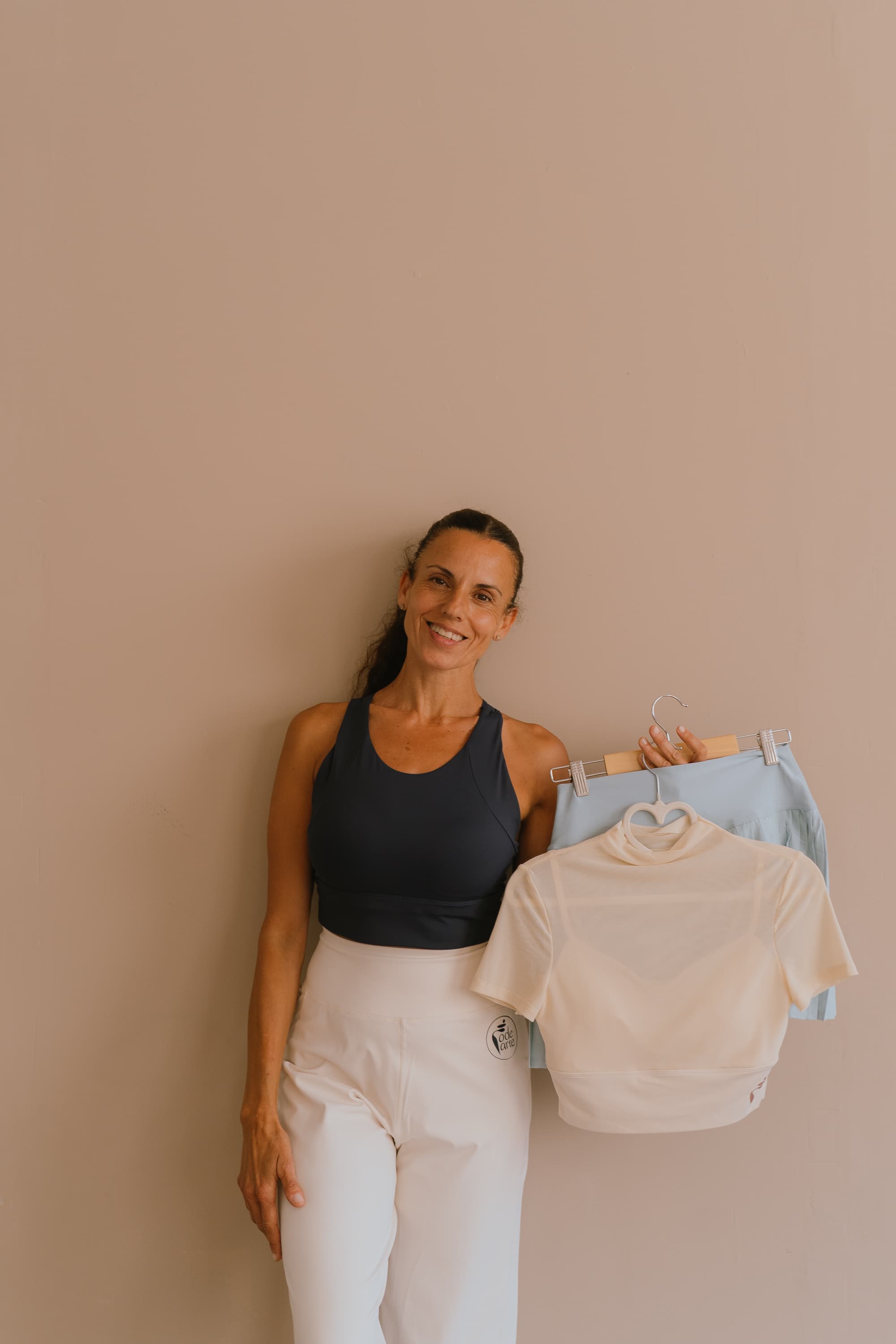 Vanesa mostrando prendas de la colección Rodearte en perchas